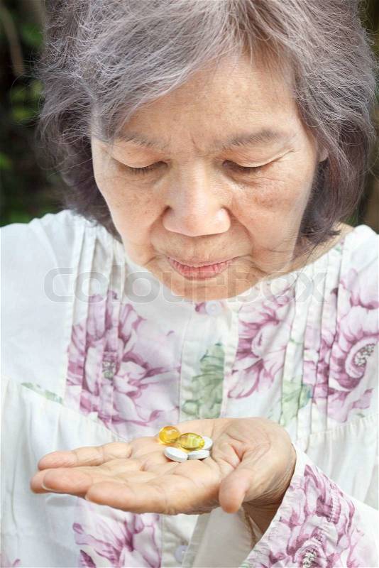 Asian Senior Woman Looking At Pills, stock photo