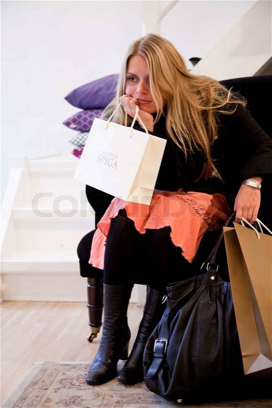 Caucasian woman shopping for clothes in a fashion store, stock photo