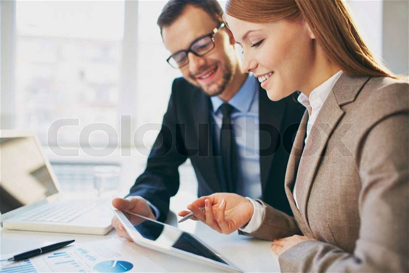 Young businesswoman explaining report to her colleague at meeting, stock photo