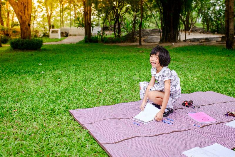 Asian girl relaxing on mat in the park outdoor, stock photo