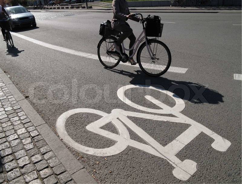 Bicycle sign and cyclists in low afternoon sun Copenhagen, Denmark. Focus on sign, stock photo