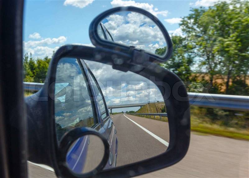 Reflection of sky with clouds in the side mirror a car, stock photo