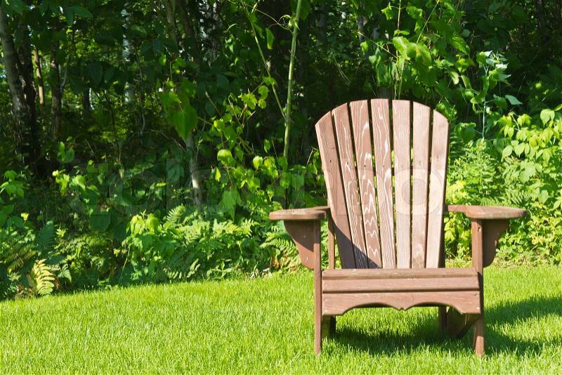 Adirondack summer lawn chair outside on the green grass, stock photo
