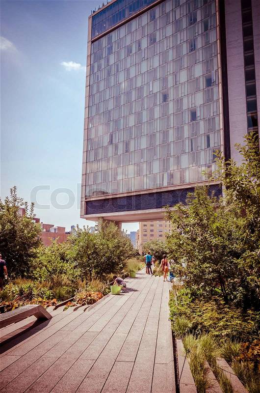 NEW YORK CITY - JULY 22: People walk along the High Line Park on July 22, 2014. The High Line is a popular linear park built on the elevated former New York Central Railroad spur in Manhattan, stock photo