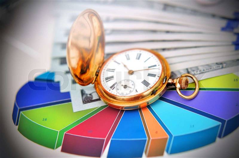 Business pie charts and antique gold pocket watch on table, stock photo