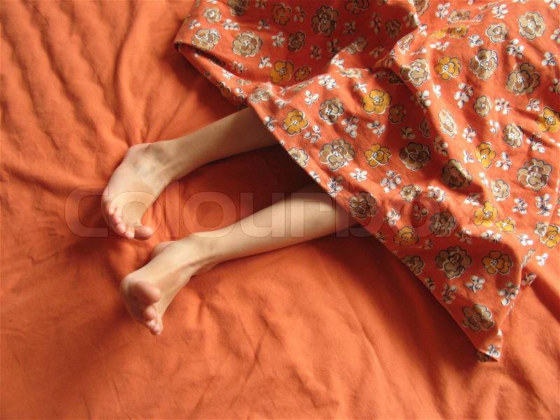 The feet of seven year old boy in the moment he wakes up, stock photo