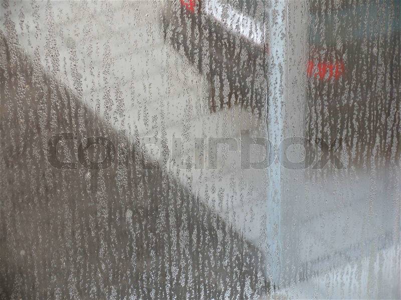 Parked car seen through a wet window, stock photo