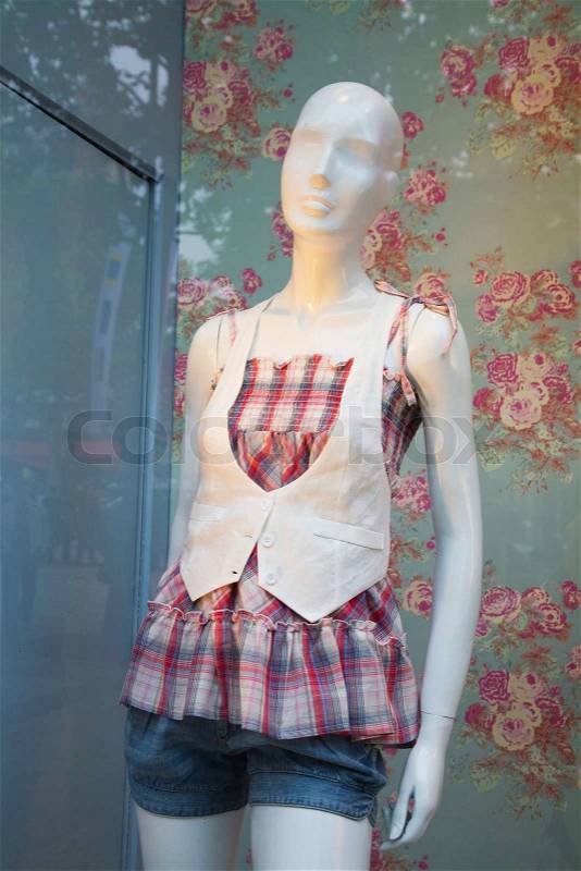 Female summer fashion Paris France seen through a shop window, stock photo