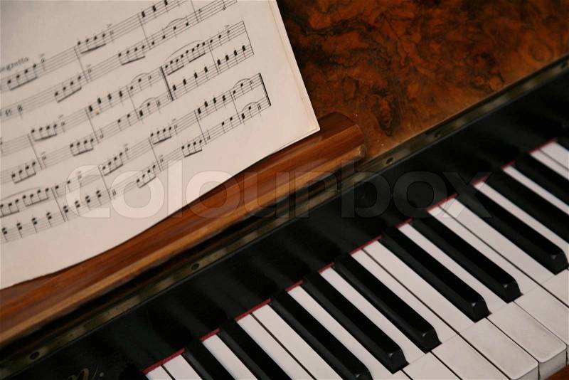 Antique piano with sheet music. Natural light, stock photo