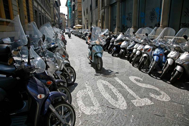 Lots of parked scooters and motorbikes in the center of Florence Italy, stock photo