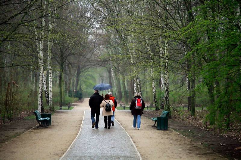 Family walking in Tiergarten Park on a rainy day - Berlin Germany, stock photo