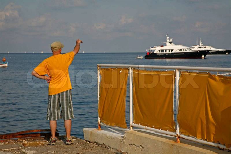 French man waiving goodbye in the low evening sun at Saint Jean, Cap Ferrat, France, stock photo