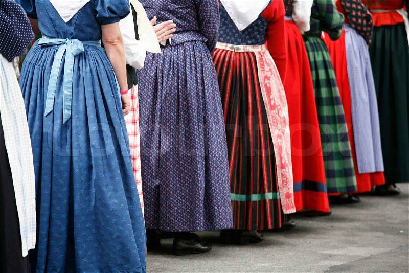 Group of folck dancer women in their colorful old dresses. Shallow DOF. Focus on left blue dress, stock photo