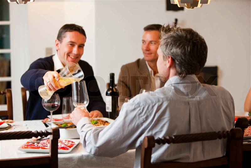 A group of friends enjoying dinner with good food and wine, stock photo
