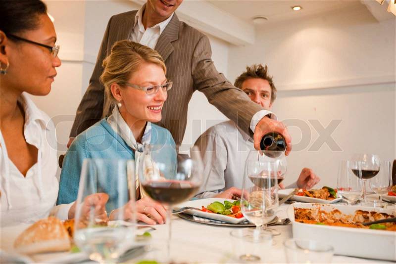 A group of friends enjoying dinner with good food and wine, stock photo