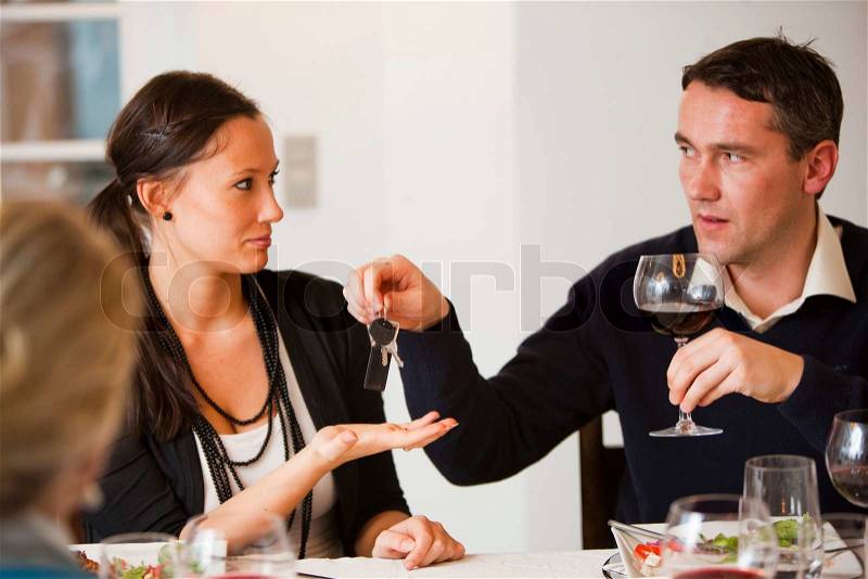 A man giving his car key to his friend after drinking too much alcohol, stock photo