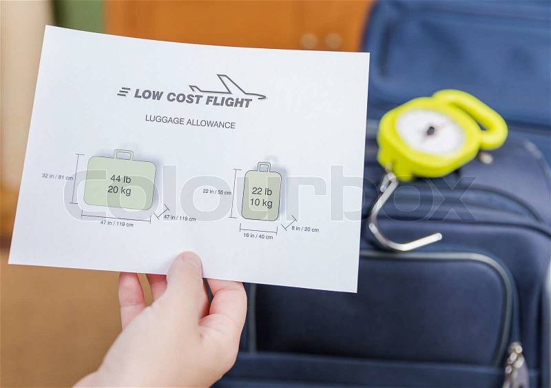 Low cost airlines luggage restrictions and baggage ready to weight with a steelyard balance on the background, stock photo