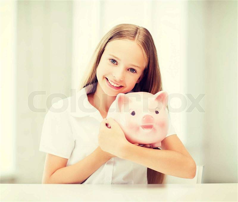 Education, school and money saving concept - child with piggy bank, stock photo