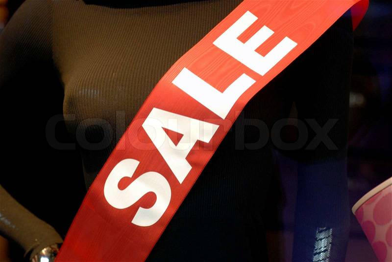Sale. White text on red label in a shop window, stock photo