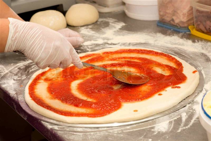 Currently pizza application of tomato sauce, stock photo