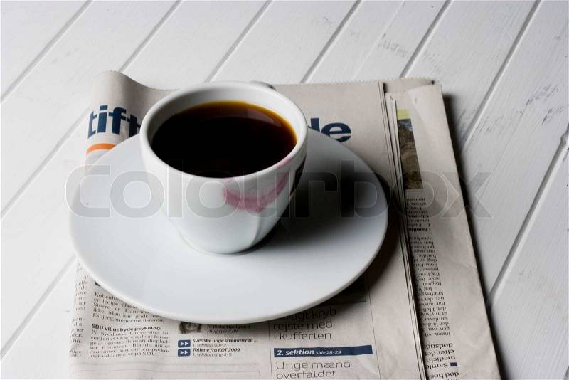 Coffee cup with lipstick stain and newspaper, stock photo