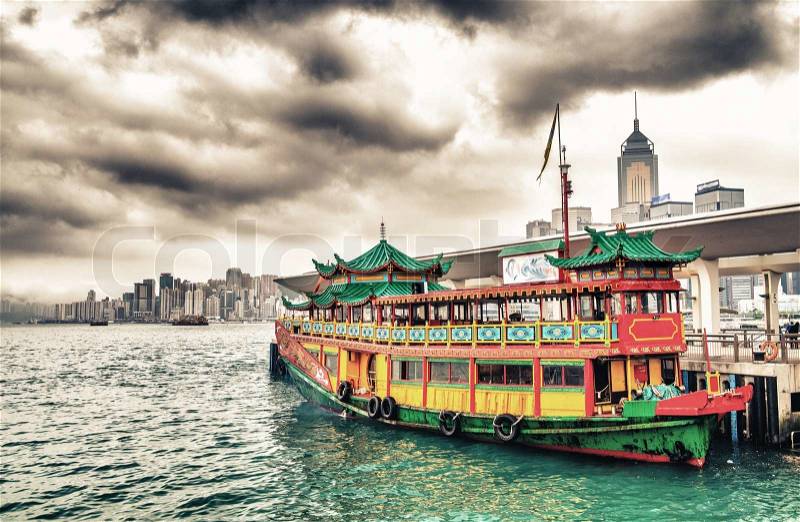 Hong Kong port. Colourful old cruise ship with city skyline on background, stock photo