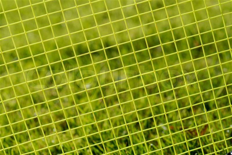 Green badminton racket strings close-up. Focus on the strings, stock photo