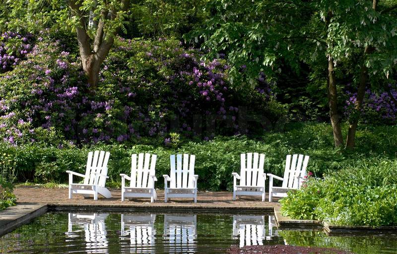 Wooden white patio chairs in springtime park in Hamburg, Germany, stock photo