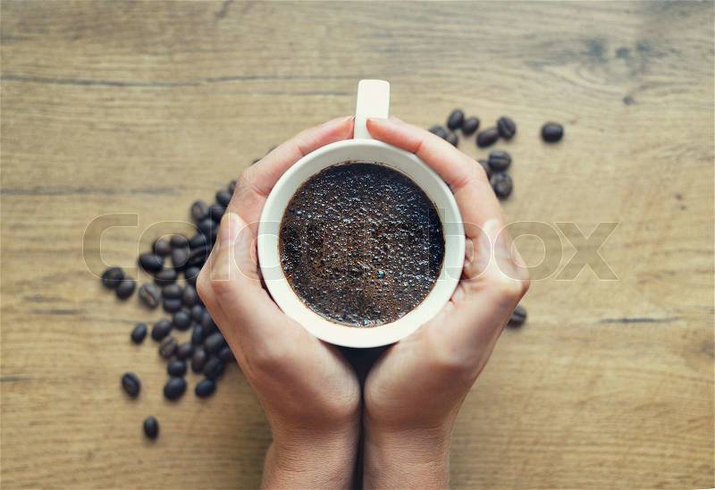 Woman holding cup of freshly brewed coffee, stock photo