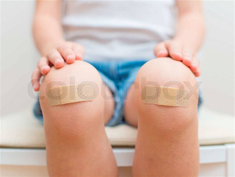 Child knee with an adhesive bandage, stock photo