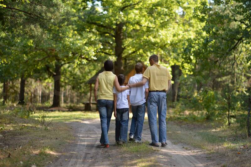 Cute happy family walking in summer forest, stock photo