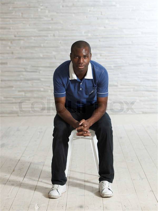 Portrait - african man sitting on a chair, stock photo