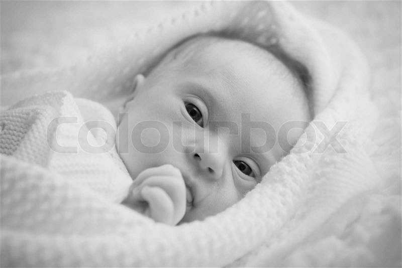 Newborn with Down syndrome is quiet and looks, stock photo