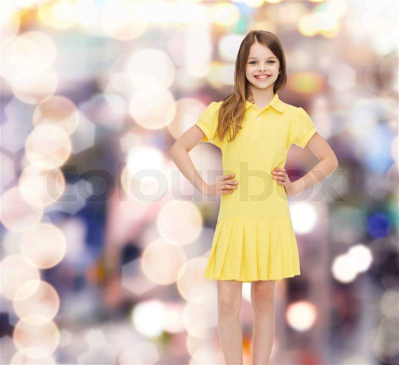 Happiness, childhood and people concept - smiling little girl in yellow dress, stock photo