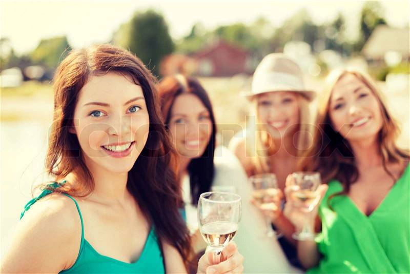 Summer holidays, vacation and celebration concept - smiling girls with champagne glasses, stock photo
