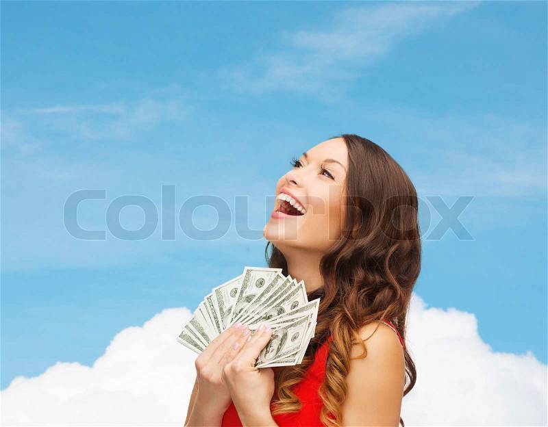 Sale, banking and people concept - smiling woman in red dress with us dollar money over blue sky with white cloud background, stock photo