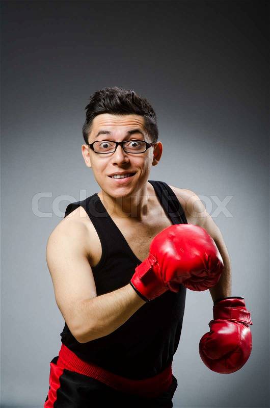 Funny boxer with red gloves against dark background, stock photo