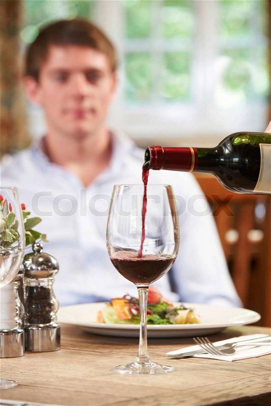 Waitress Pouring Customer Glass Of Red Wine, stock photo