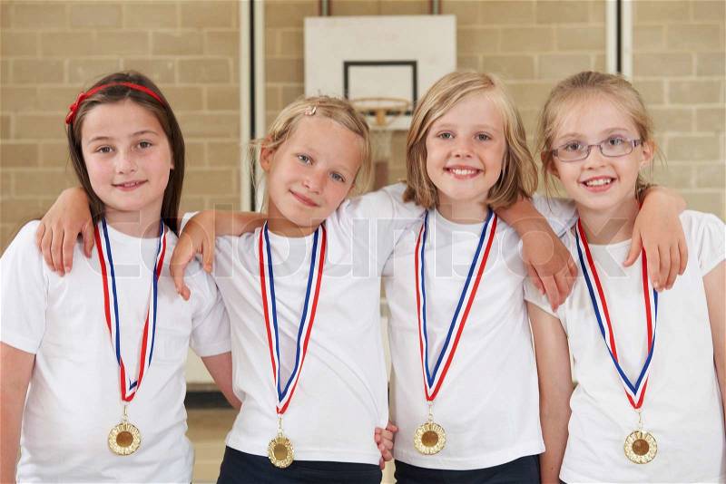 Female School Sports Team In Gym With Medals, stock photo