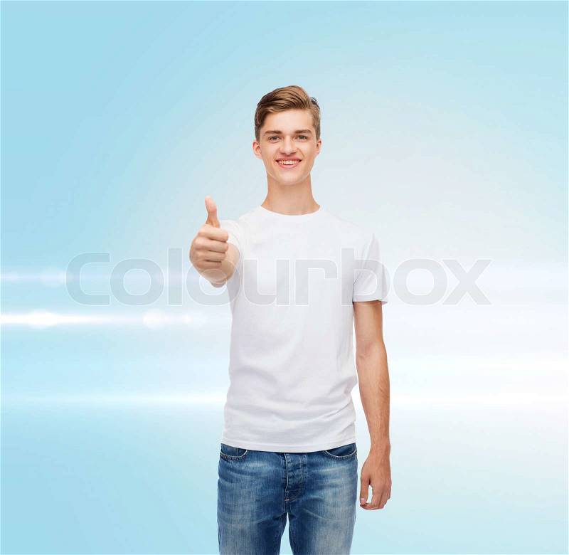 Gesture, advertising and people concept - smiling young man in blank white t-shirt showing thumbs up over blue laser background, stock photo