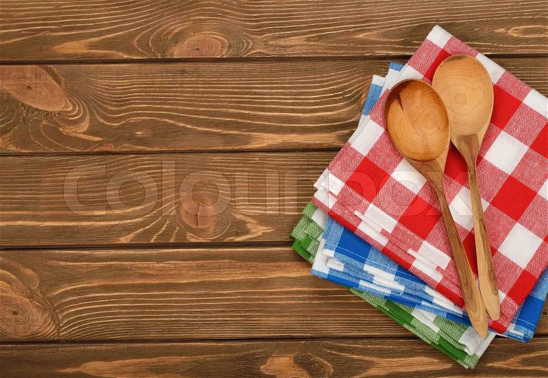 Wooden spoon and napkin on a brown background, stock photo