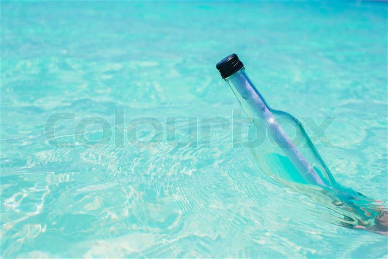 Bottle with a message in the hand background blue sky, stock photo
