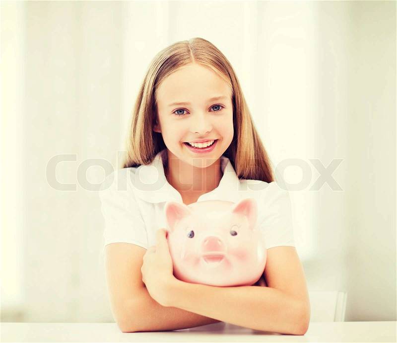 Education, school and money saving concept - child with piggy bank, stock photo