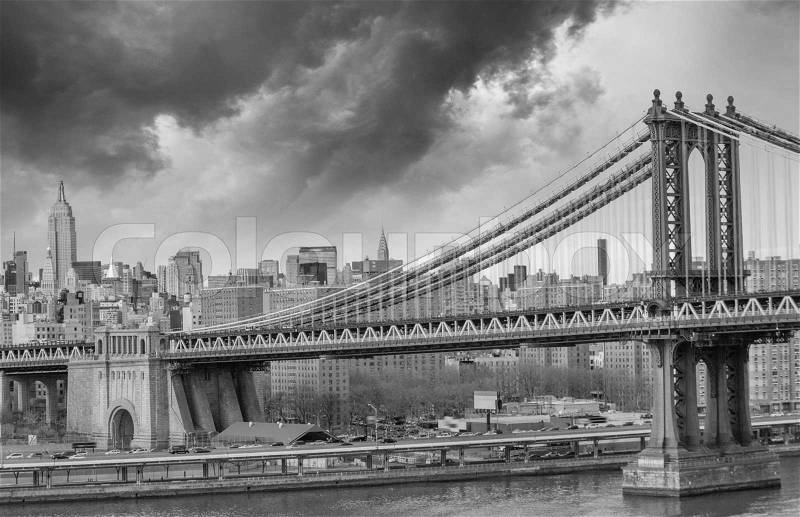 Brooklyn Bridge with Manhattan skyline panorama in the afternoon with cloud and river reflection over East River in New York City, stock photo