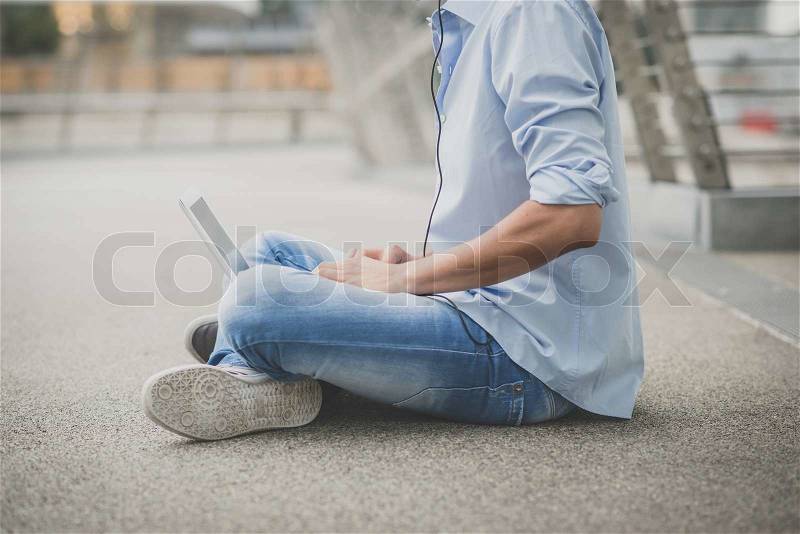 Close up of young model hansome blonde man with notebook and headphones in the city, stock photo