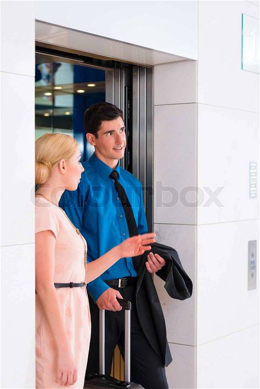 Couple waiting for hotel elevator or lift, stock photo