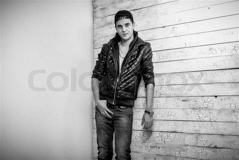 Monochrome portrait of sexy stylish man leaning against two walls, stock photo