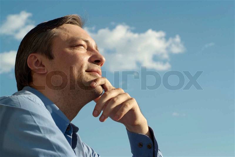 Thoughtful man on nature against the sky, stock photo