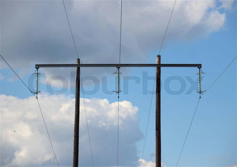Simple electrical tower in grass field with clouds, stock photo