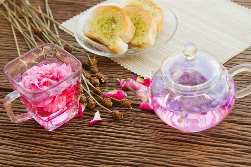 Rose tea and homemade garlic bread on table in the garden, afternoon tea break, stock photo